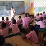 Students at Tezo Primary School listen attentively to their teacher.