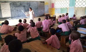 Students at Tezo Primary School listen attentively to their teacher.