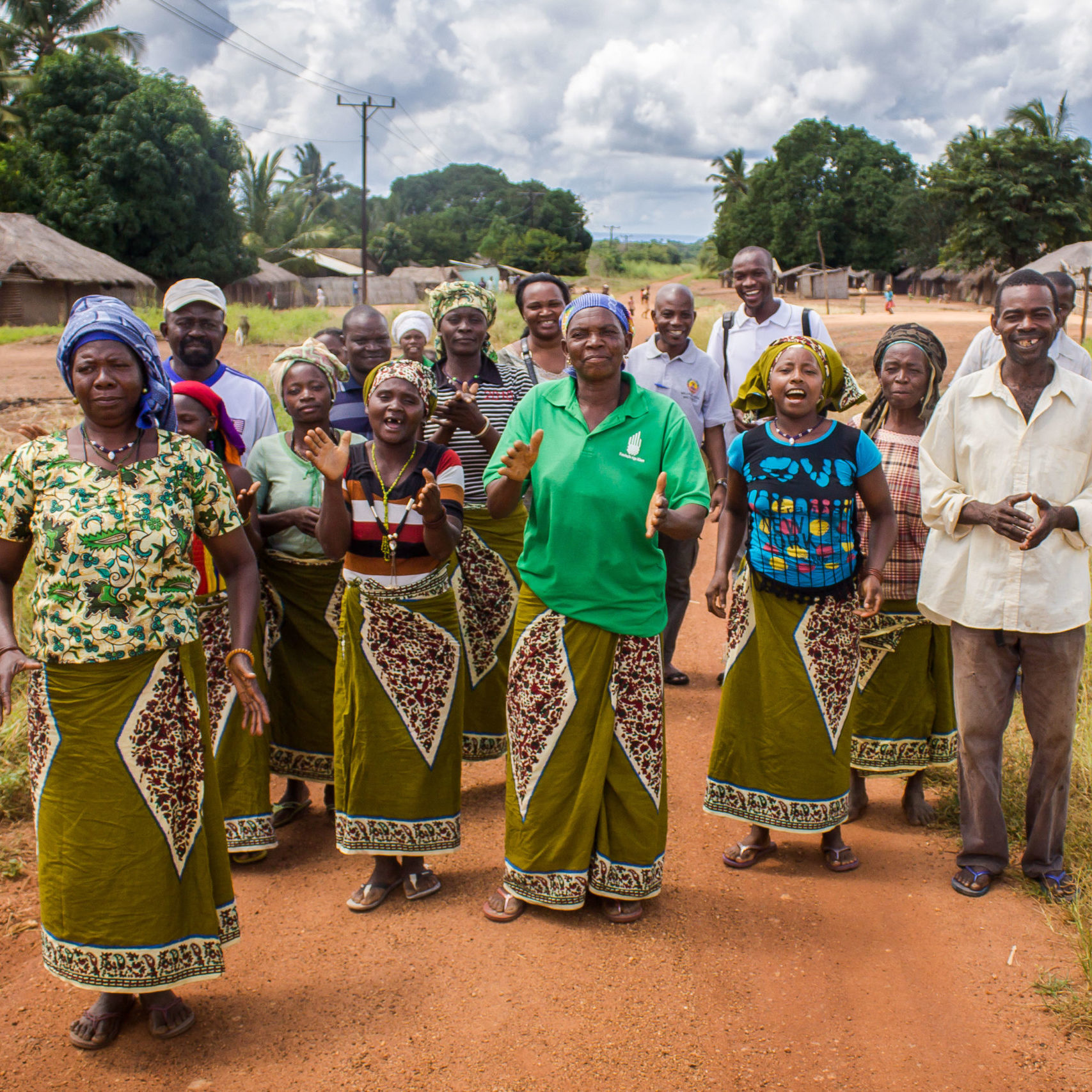 A group of female and male farmers walk together in fields in Mozambique
