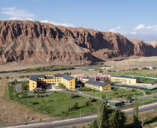 Colorful buildings are shown in the center with a large mountain behind