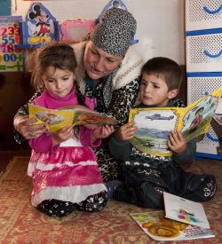Teacher reading to a young boy and girl in Tajikistan. Reading for Children, Aga Khan Development Network