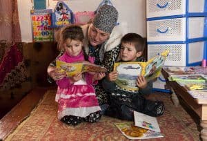 Teacher reading to a young boy and girl in Tajikistan. Reading for Children, Aga Khan Development Network