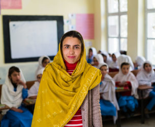 A principal stands in front of a classroom at a primary school in Pakistan