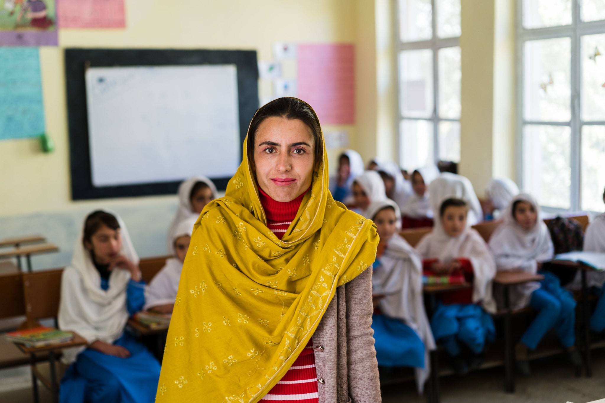 A principal stands in front of a classroom at a primary school in Pakistan
