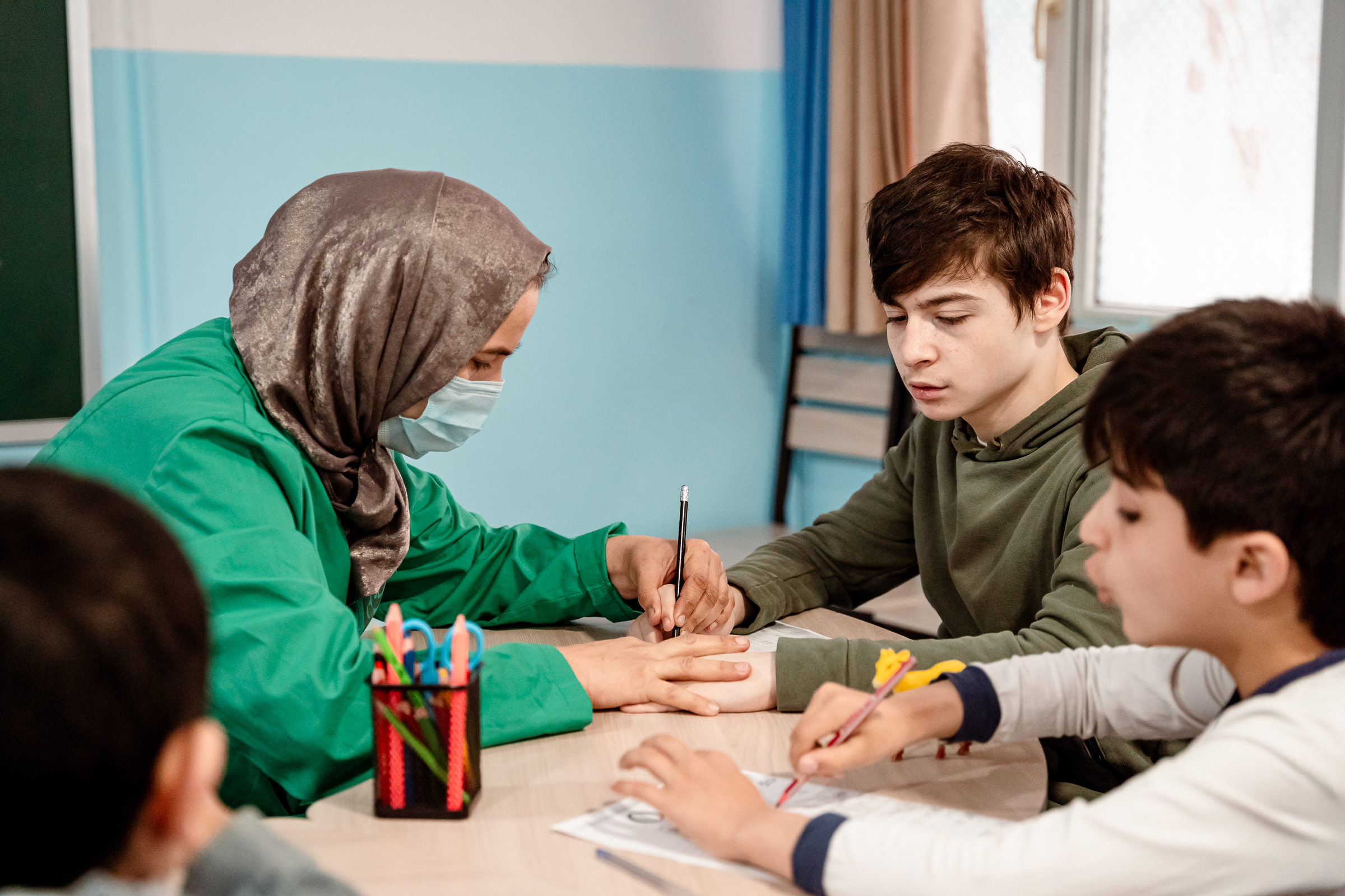 A teacher works with special needs students at a specialized learning center in Tajikistan