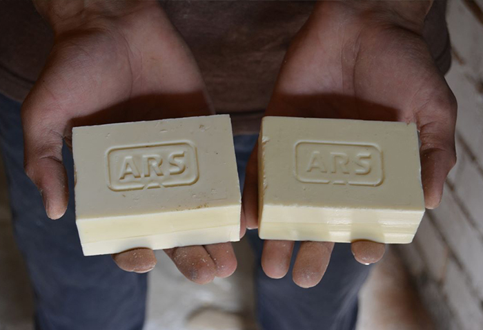 Two hands are pictured holding soap, representing how soap sparked job growth in Arslanbob, Kyrgyz Republic
