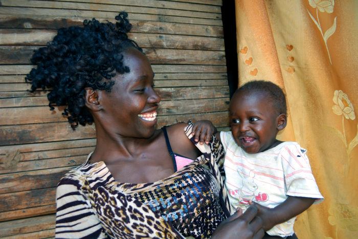 A Kenyan mother holds her smiling baby.