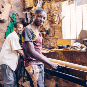 Economic Inclusion: A young Kenyan man works in a carpentry shop.