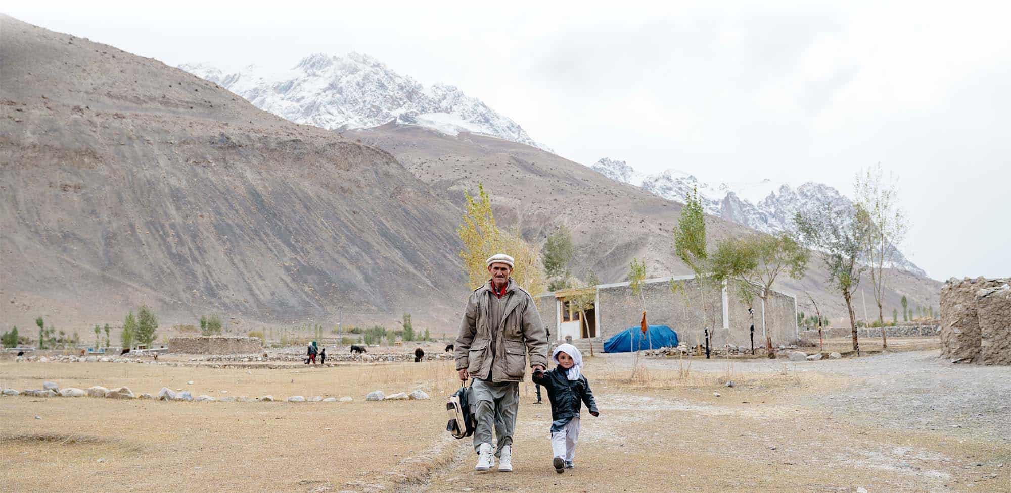 A grandfather and young grandaughter walk to school in Northern Pakistan.