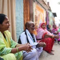 Residents of Patna, India sit in front of their homes and discuss the need for sanitation facilities