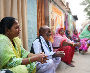 Residents of Patna, India sit in front of their homes and discuss the need for sanitation facilities