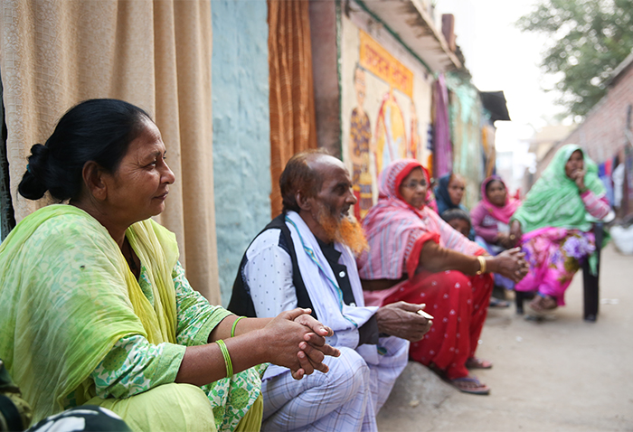 Residents of Patna, India sit in front of their homes and discuss the need for sanitation facilities