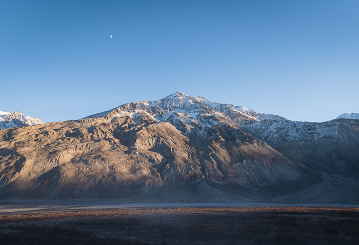 A snow-capped mountain is pictured at dusk