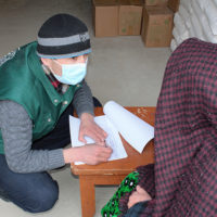 Mamadnasim Fozilov AKAH registering food assistance recipient Khoro Dec 2020 700x478