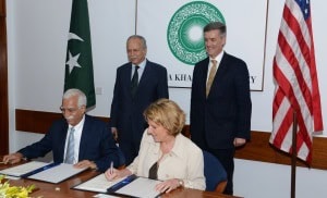 Overseas Private Investment Corporation President and CEO Elizabeth L. Littlefield (seated right) and Aga Khan University President and CEO Firoz Rasul (seated right), on behalf of the Aga Khan Hospital and Medical College Foundation, sign a Loan Agreement to provide financing for expansion of the Aga Khan University Hospital. U.S. Ambassador to Pakistan Richard Olson (standing right) and Chairman of the Board of Trustees of the Aga Khan University Ambassador Saidullah Khan Dehlavi (standing left) officiated at the ceremony.