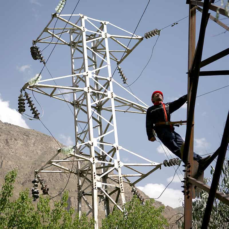 A man working for Pamir Energy in Tajikistan climbs an electrical tower.