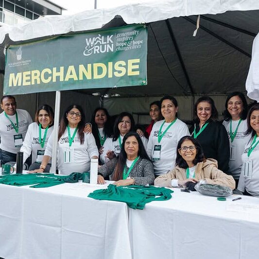 A group of volunteers stands at a merchandise booth a the Atlanta Walk & Run